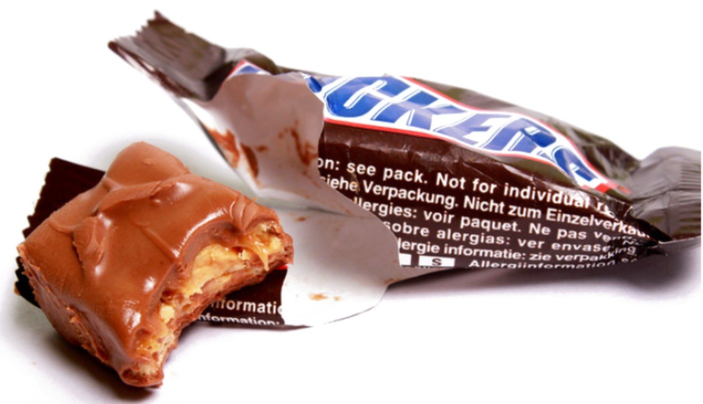 An opened Snickers bar with a bite taken out of it